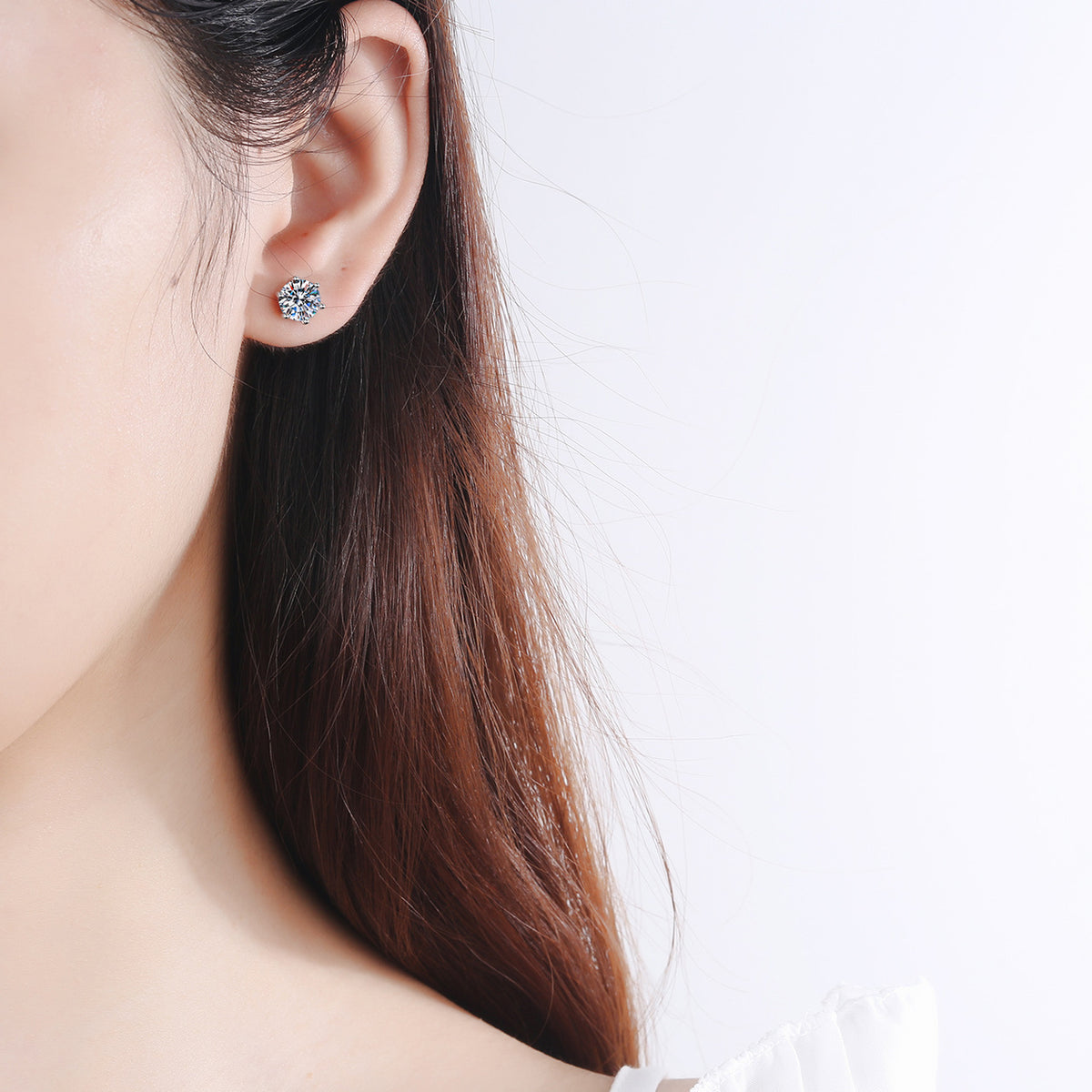 Six-prong moissanite studs on ear