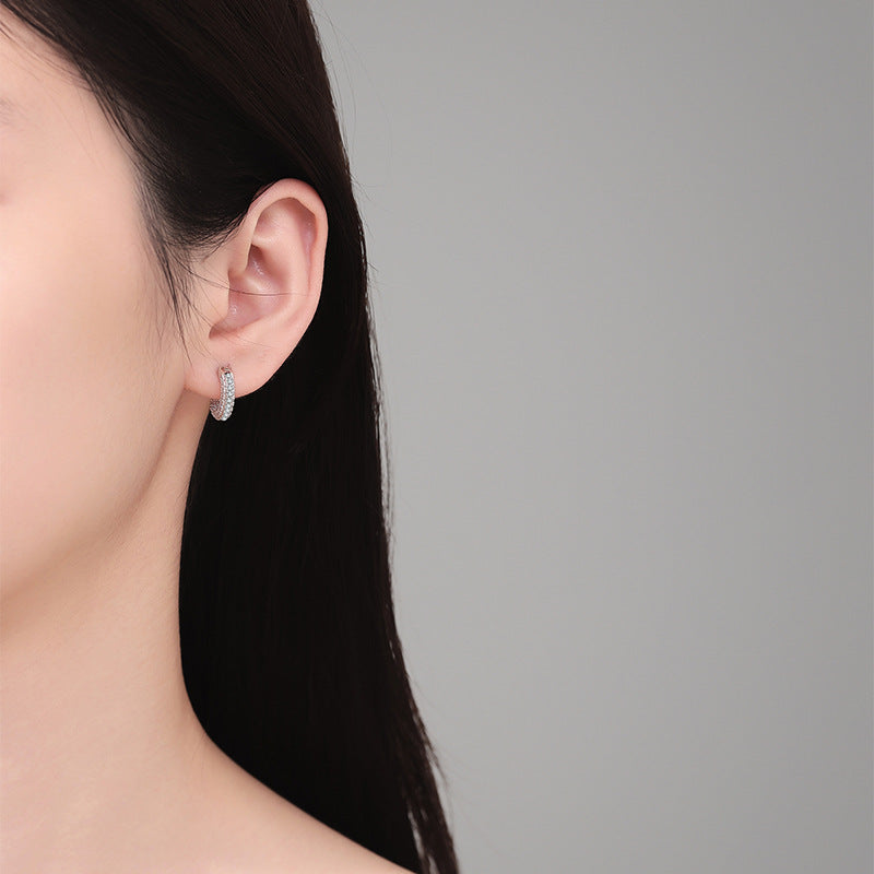 Moissanite huggie hoop worn on the ear